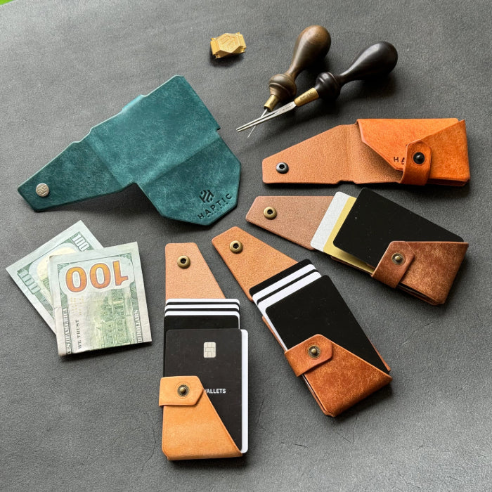 Minimalist leather wallets displayed with cards and cash, alongside tools and an innovative edge glider burnisher used in the crafting process.