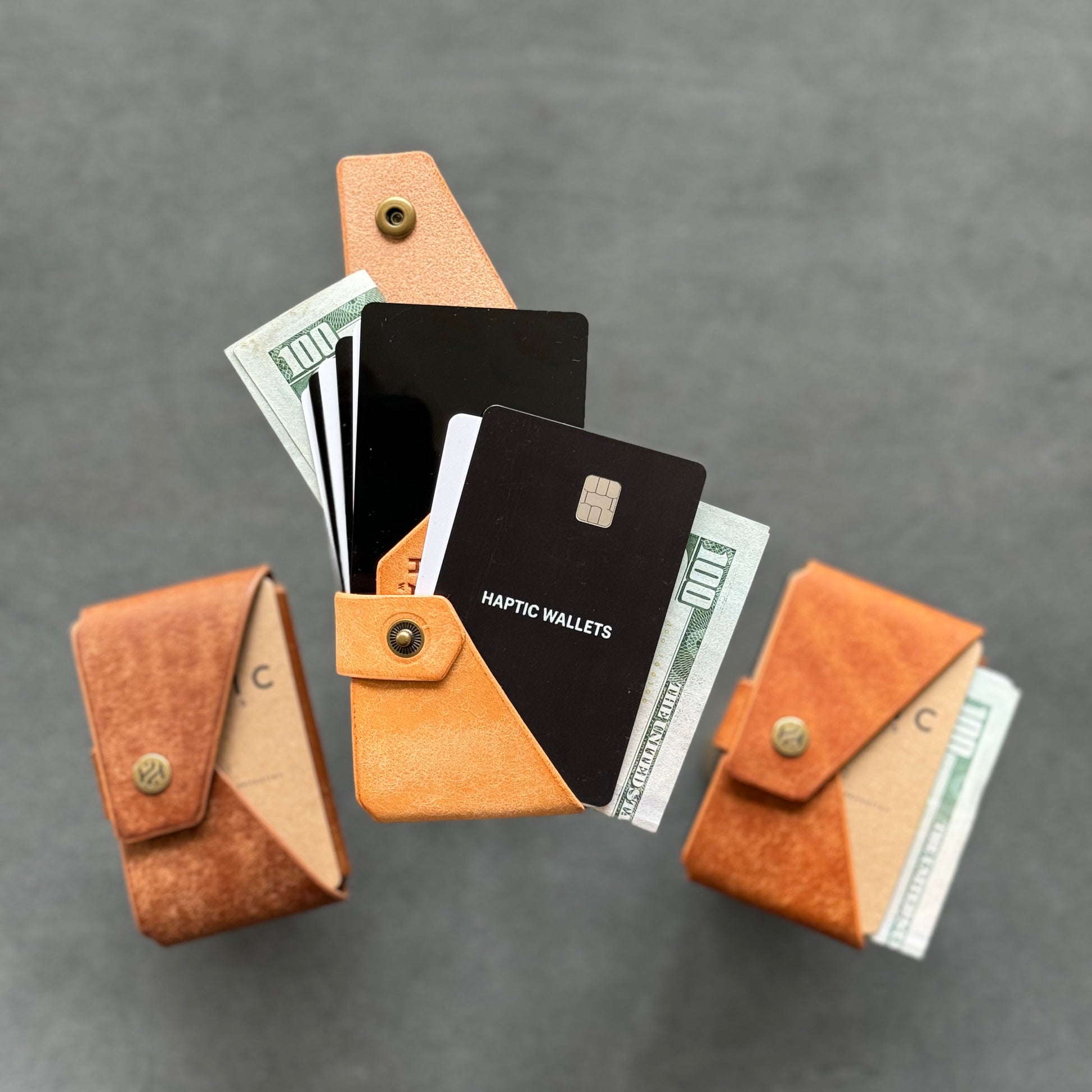 Three minimalist leather wallets, one open displaying multiple cards and cash, showcasing the compact and stylish design perfect for every day cary or as a special gift.